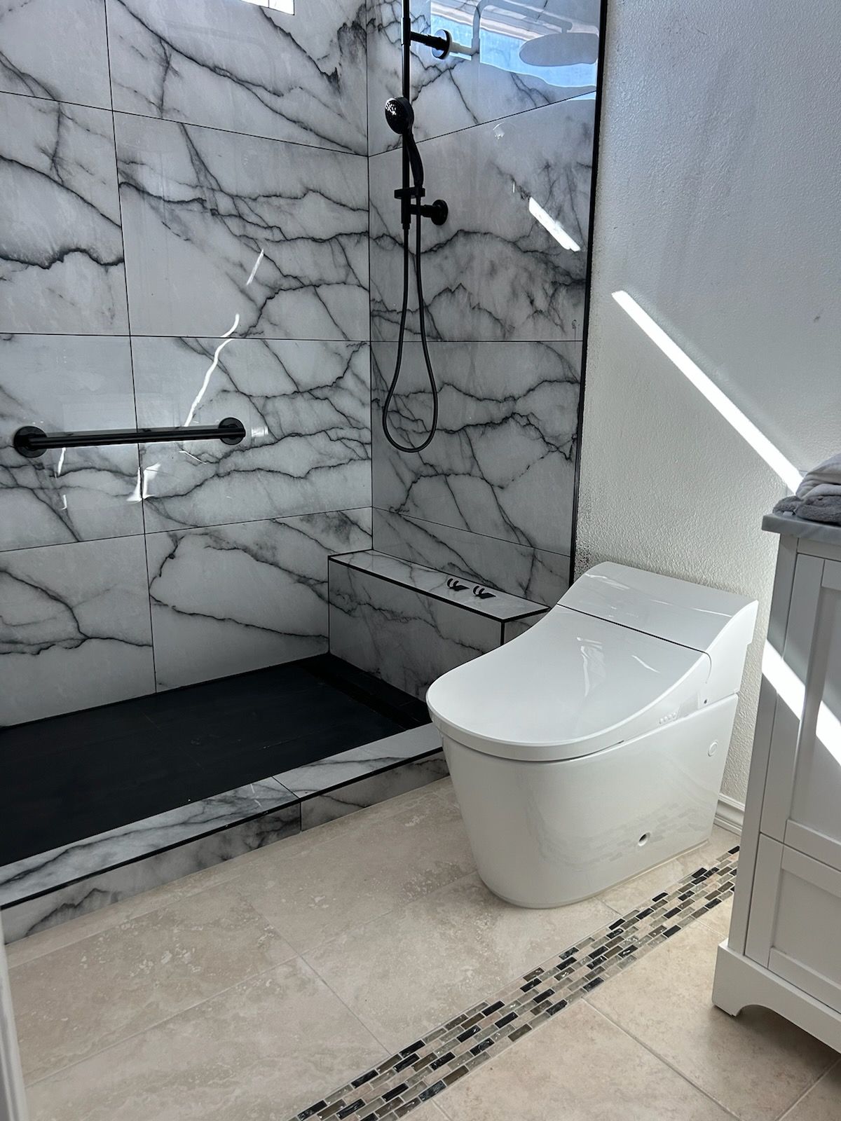 A bathroom with a toilet and a walk in shower.