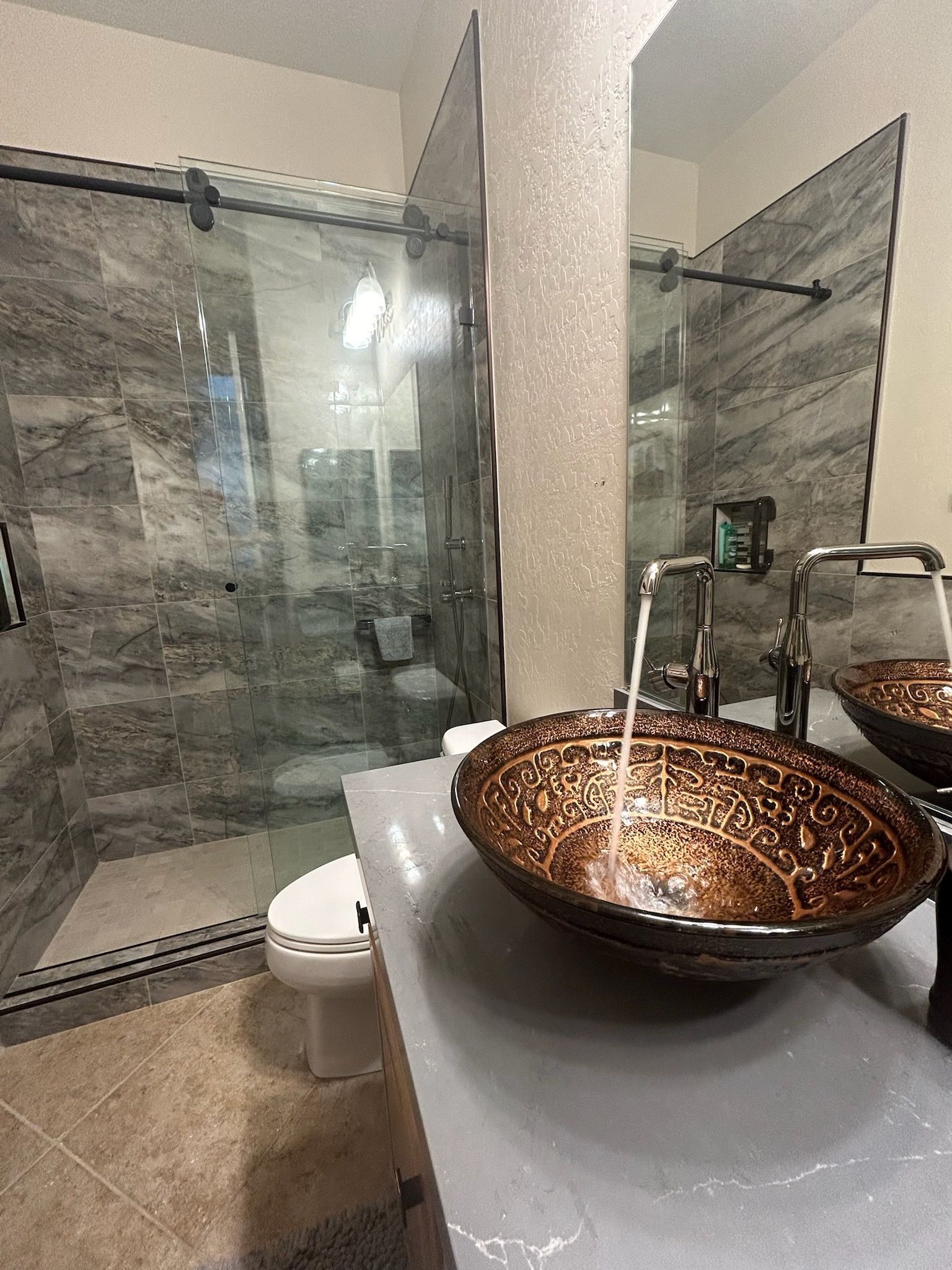 A bathroom with two sinks , a toilet and a shower.