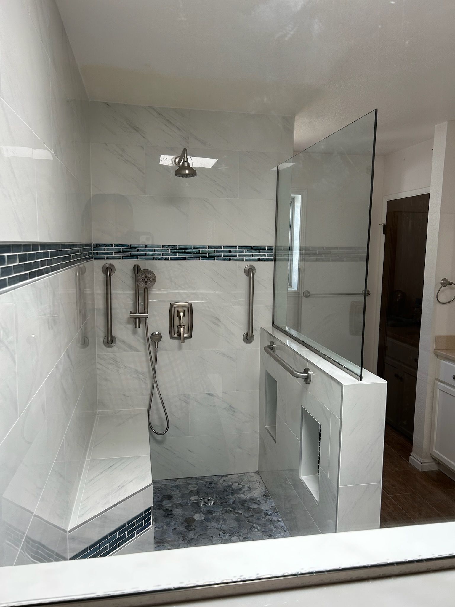 A bathroom with a walk in shower and a mirror.
