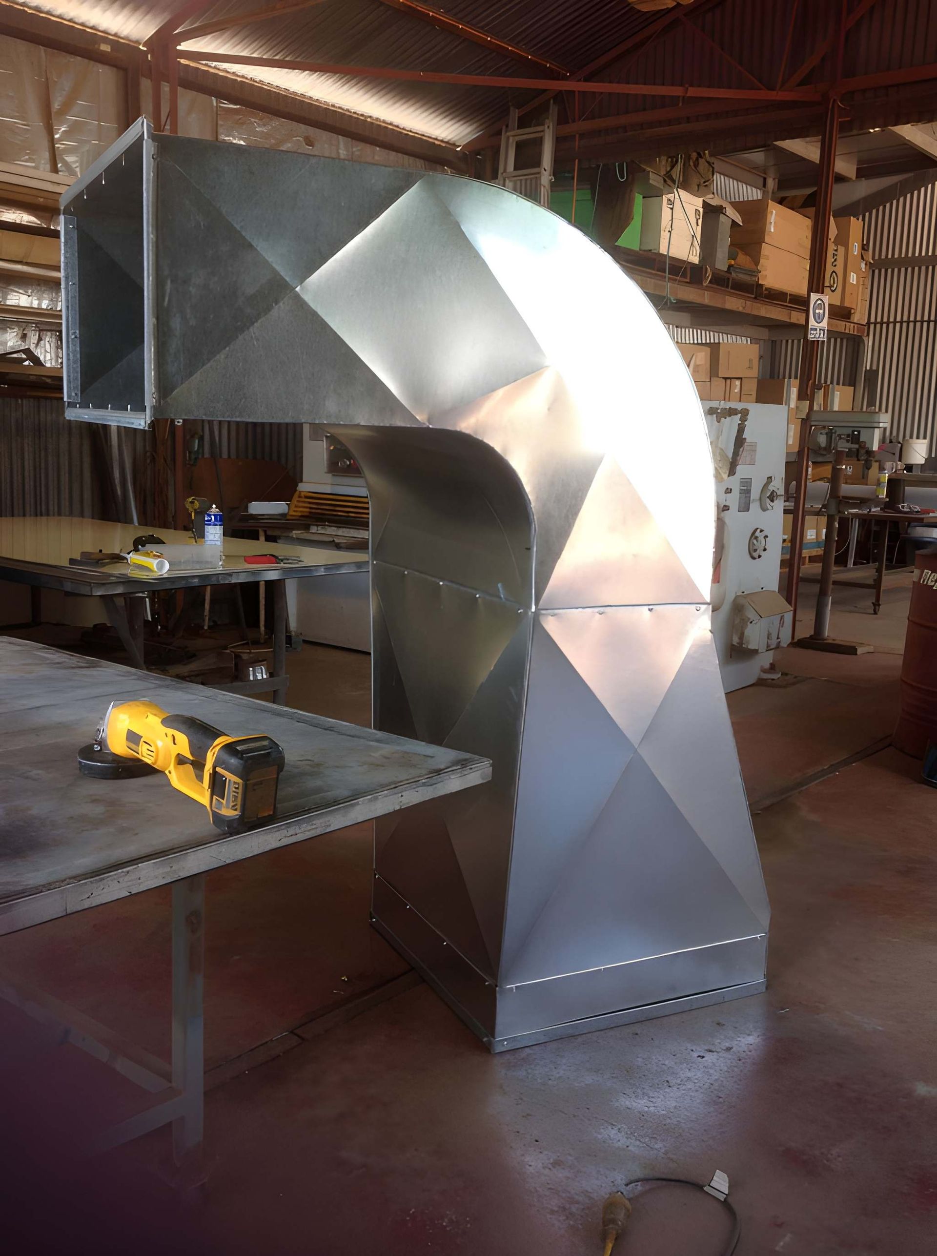 A Large, Shiny Metal Hvac Ductwork Elbow in a Workshop — Cumming Airconditioning & Sheetmetal in Ryan, QLD