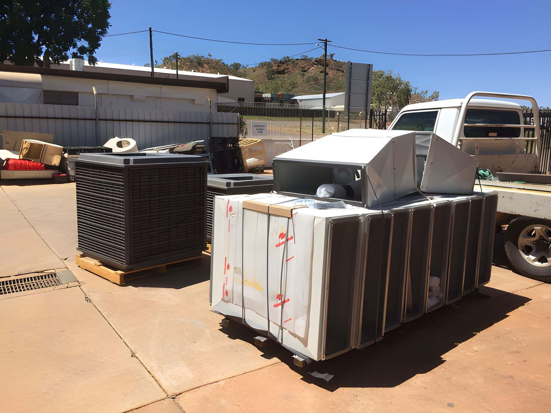 Two Industrial Units on a Concrete Surface, Likely Outdoors — Cumming Airconditioning & Sheetmetal in Ryan, QLD
