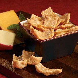 Bowl of crispy crackers with cheese on a wooden board.