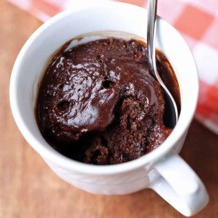 Chocolate mug cake in a white mug, spoon inserted.