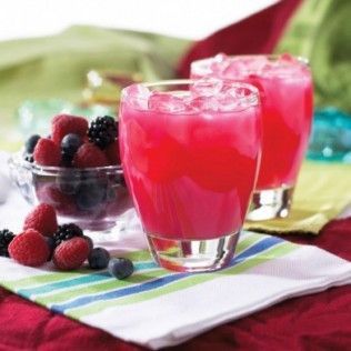 Two glasses of pink berry juice with ice, bowl of berries on striped cloth.