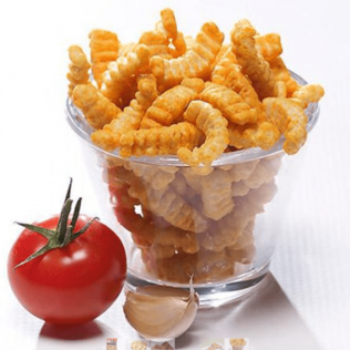 Glass of orange, ridged snacks, tomato, and garlic on white surface.