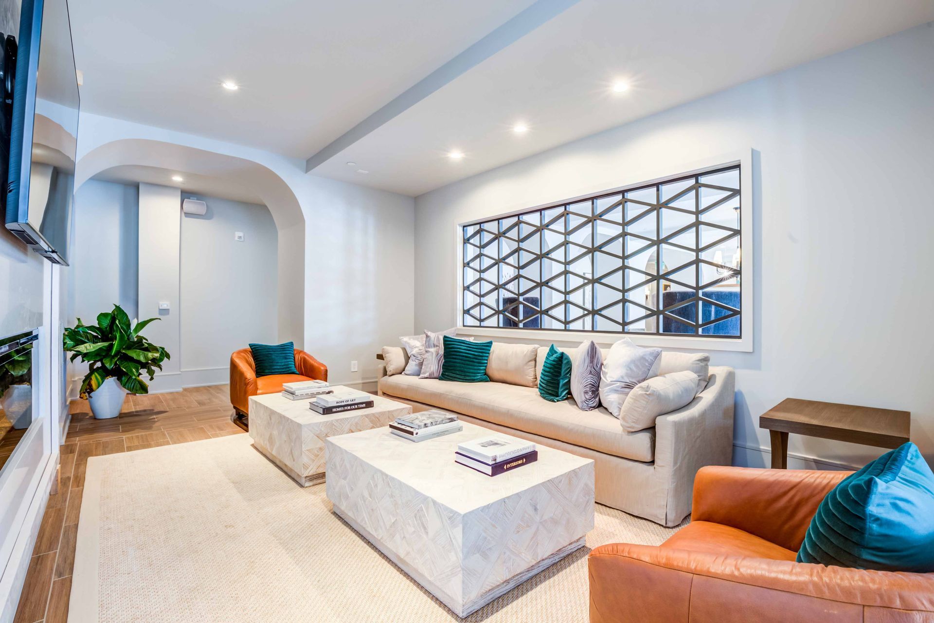 Lounge with a sofa, two chairs, coffee tables, and a geometric wall feature.