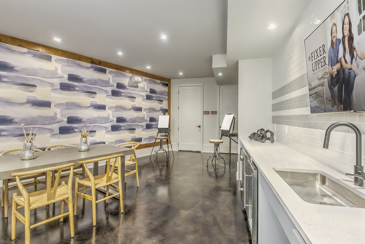 Modern office lobby with a glass-walled conference room, neutral tones, and decorative lighting.