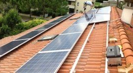 addetto mentre monta dei pannelli solari sul tetto