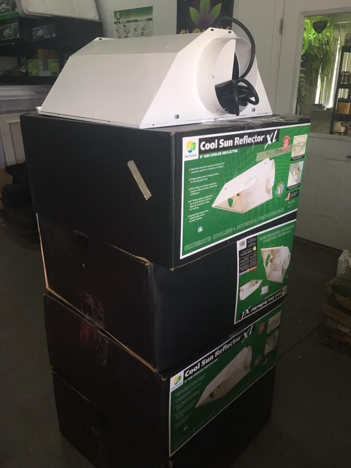 White grow light on three black boxes labeled 