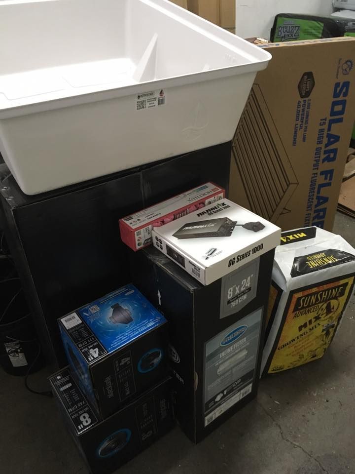 Various boxes and a white bin stacked together, including a solar panel box.