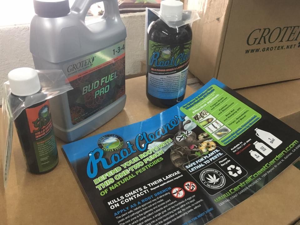 Bottles of plant fertilizer and root cleaner on a cardboard box, with a brochure.