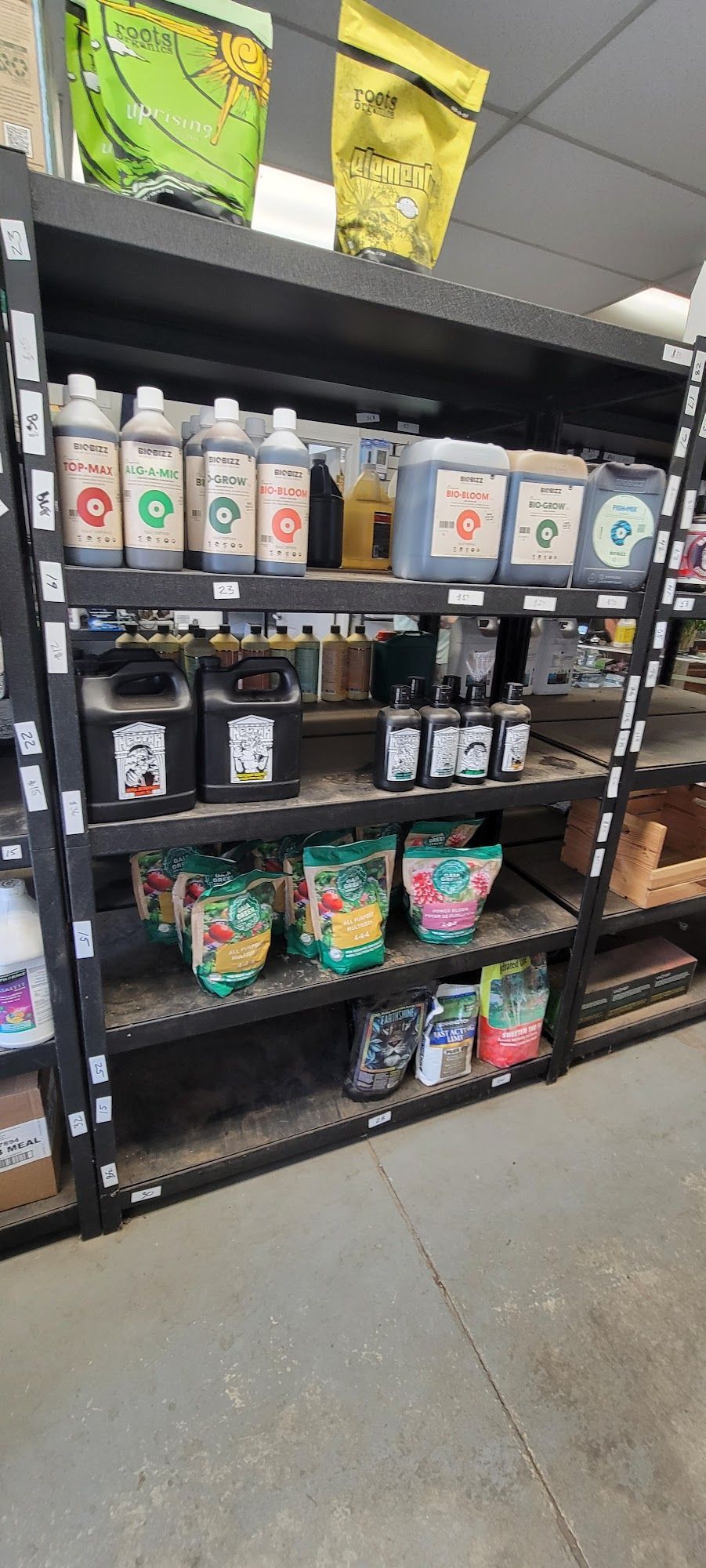 Shelves in a store filled with gardening supplies like liquids and bag products.