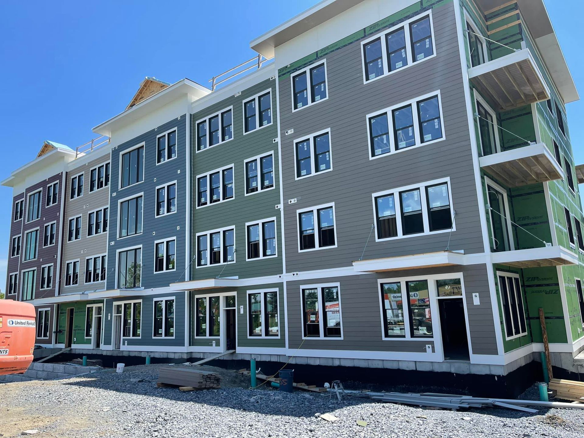 Multi-story apartment building under construction with various colored siding.
