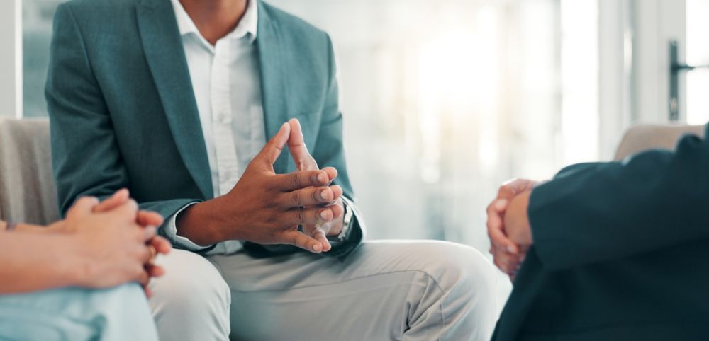 Tense HR compliance meeting between three professionals in an office