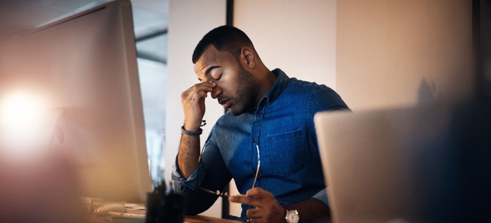 Employee feeling stressed and overwhelmed during early onboarding at a workplace.