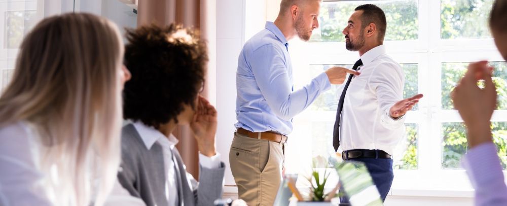 Coworkers arguing in an office showing a toxic work environment