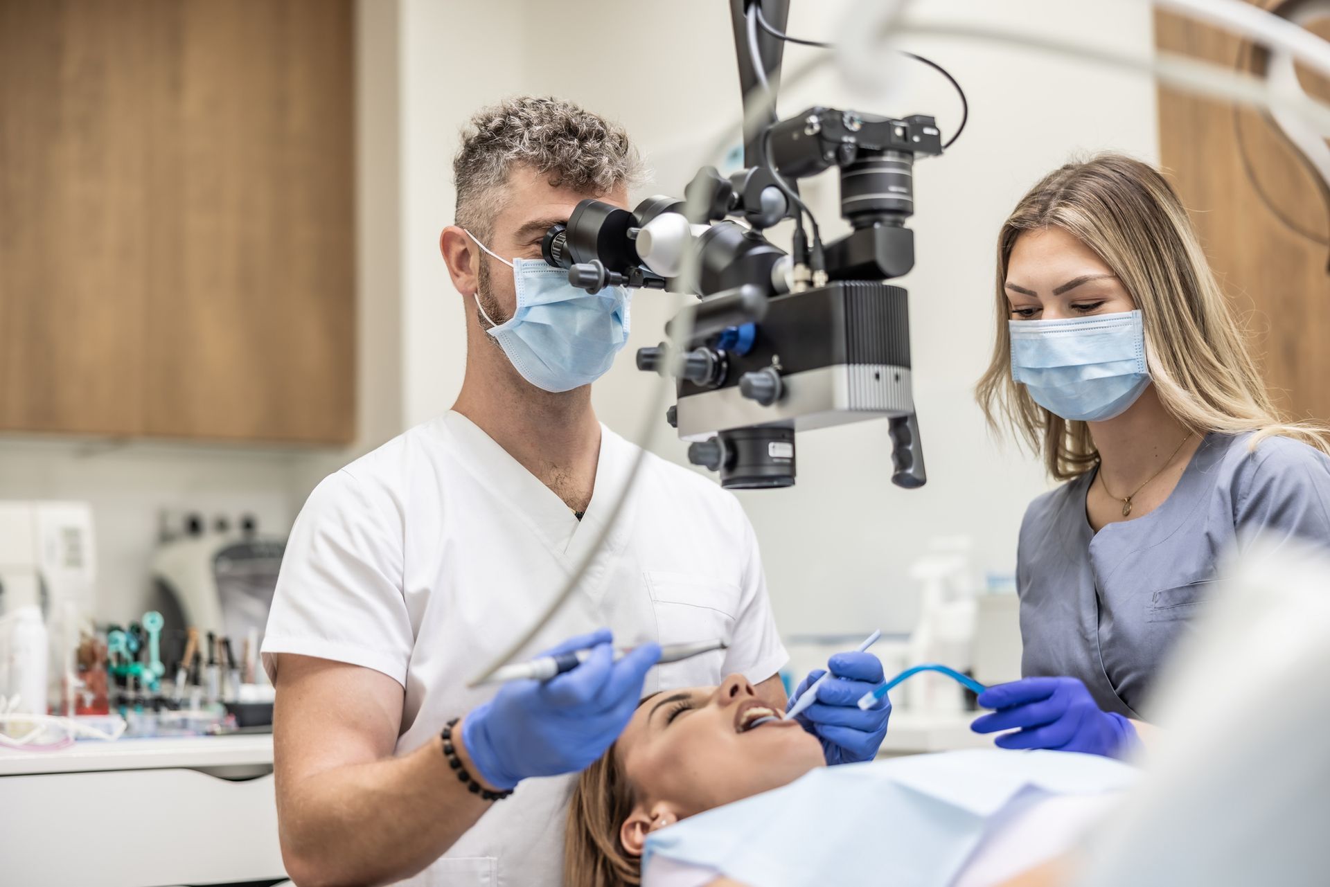 Dentists are examining the patient’s teeth with a microscope for a dental implant evaluation. Dentists are examining the patient’s teeth with a microscope for a dental implant evaluation.