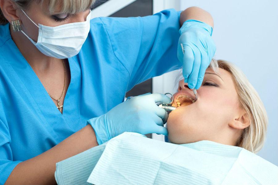 Dentist Removing Patient's Wisdom Tooth — San Diego, CA — San Diego Oral Maxillofacial