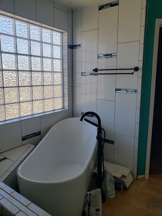 A bathroom with a bathtub and a window