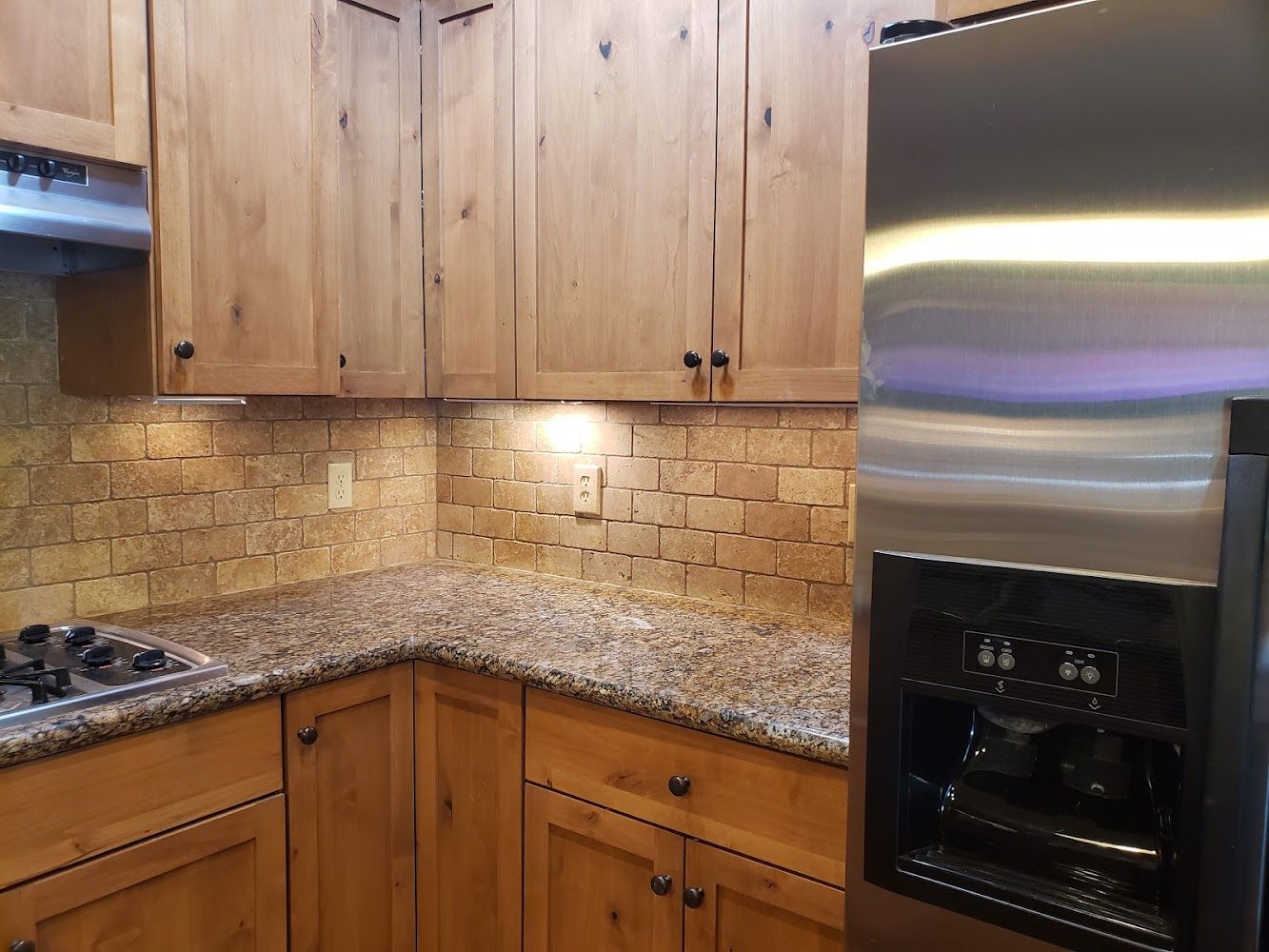 A kitchen with stainless steel appliances and wooden cabinets