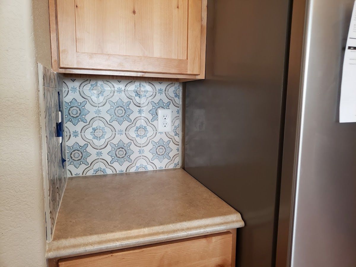 A kitchen with a stainless steel refrigerator and a wooden cabinet.