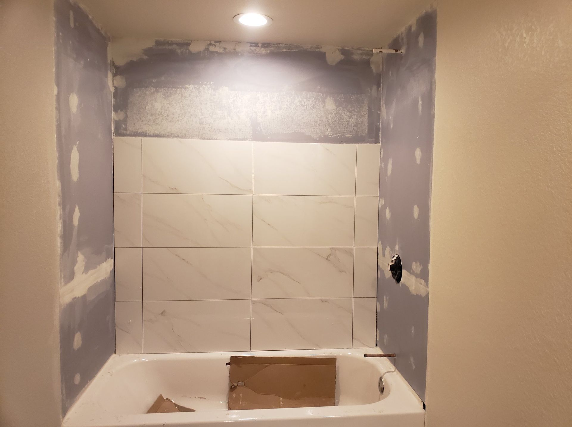 A bathtub is sitting in a bathroom under construction.