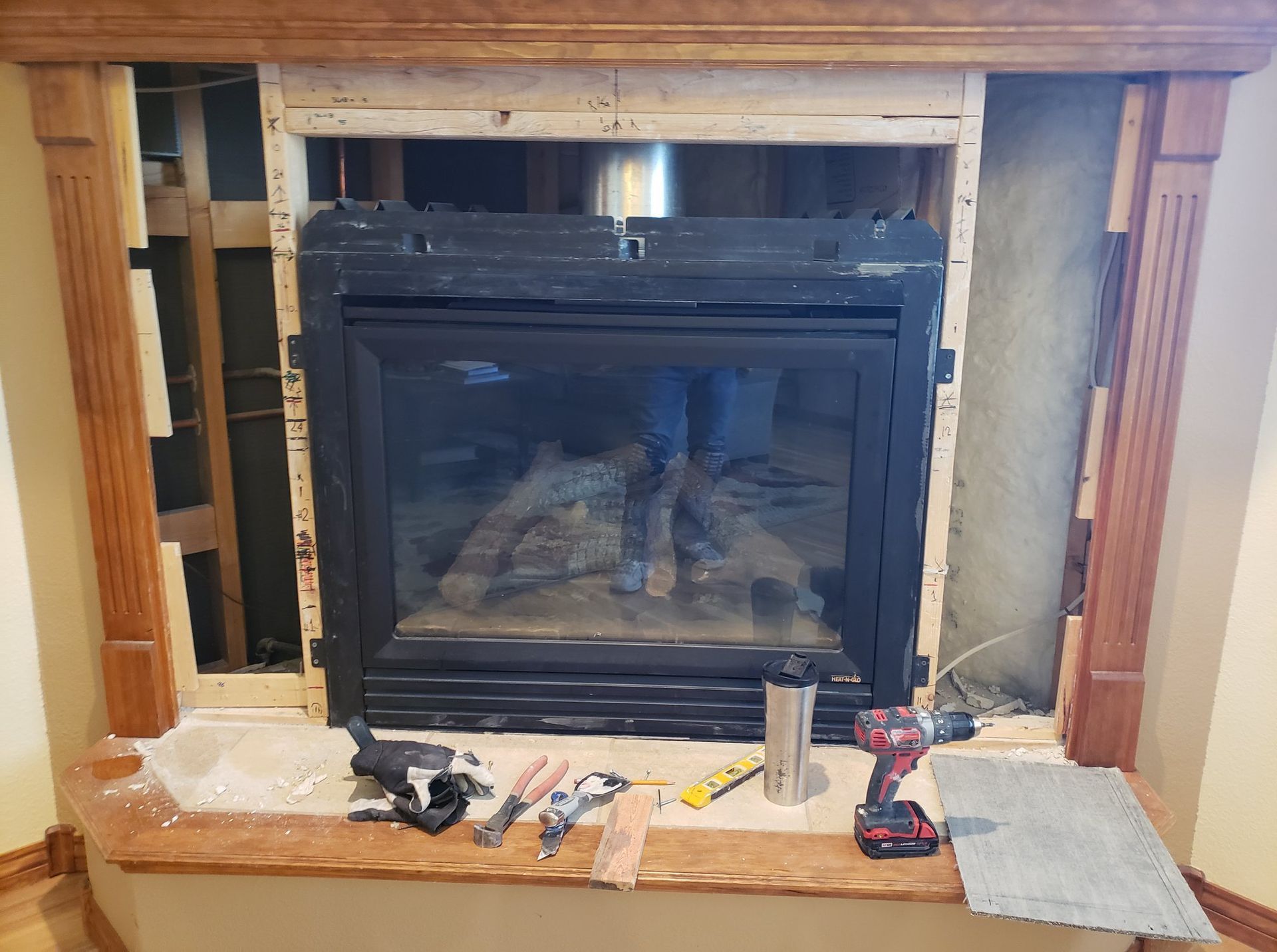 A fireplace is being remodeled in a living room.
