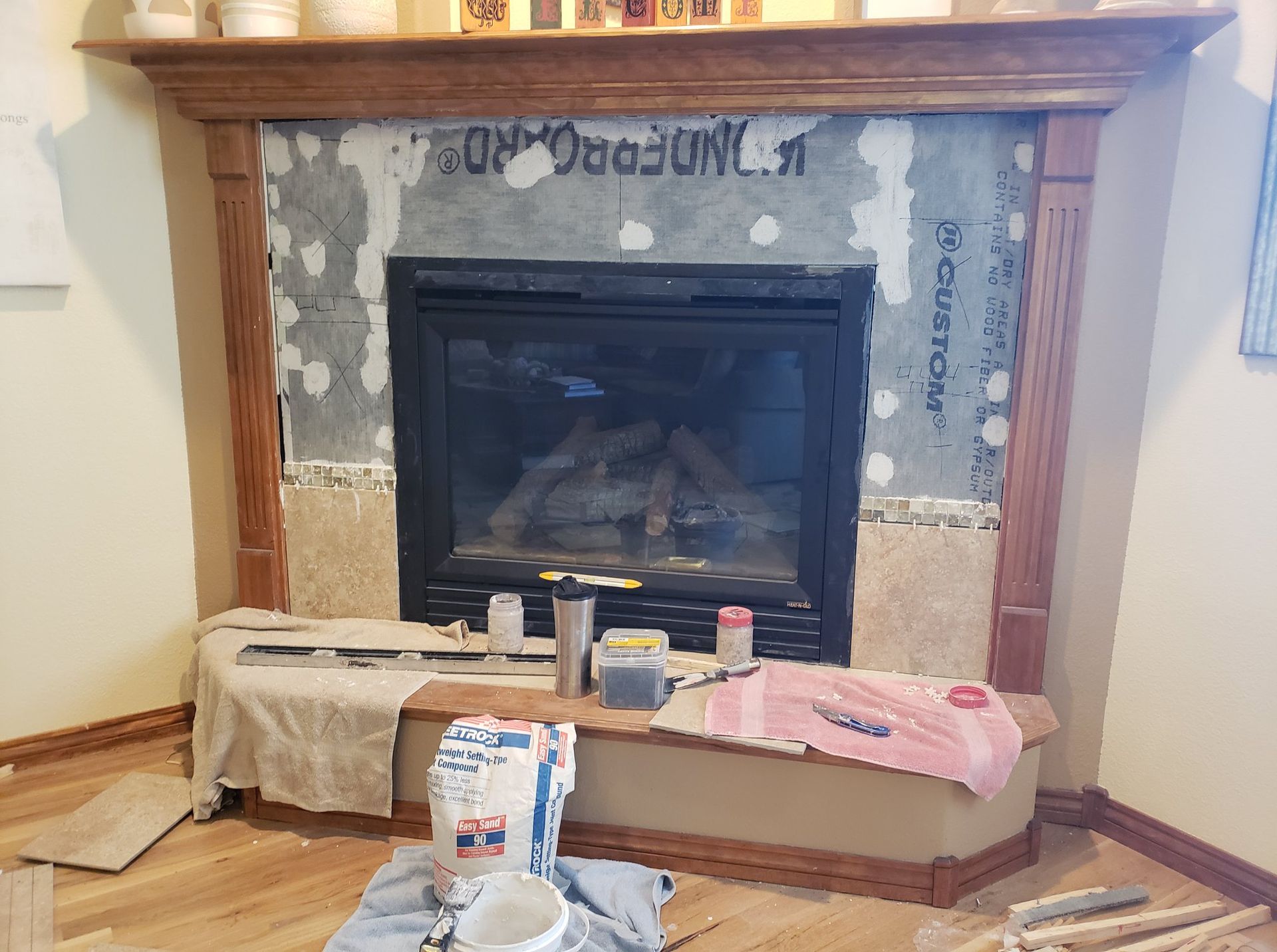 A fireplace is being remodeled in a living room.