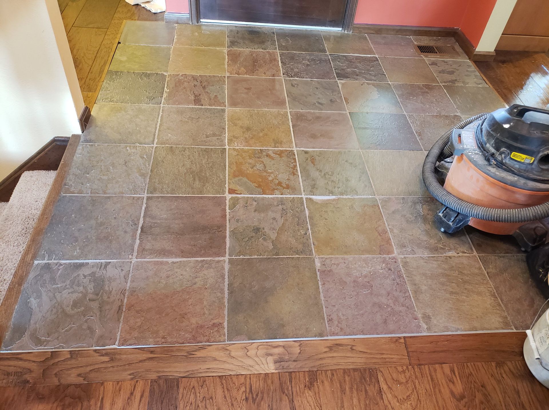 A vacuum cleaner is sitting on a tiled floor in a room.
