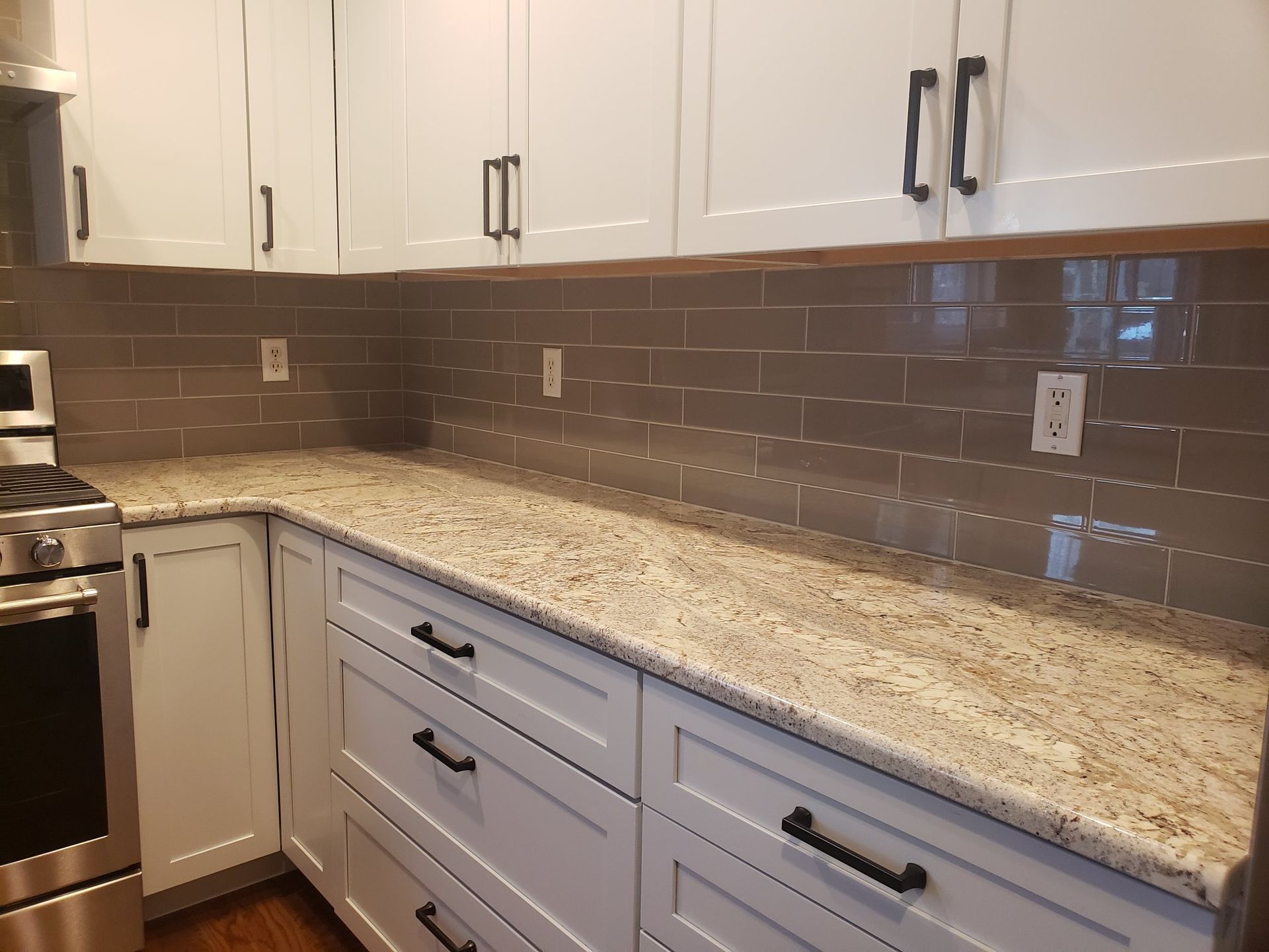 A kitchen with white cabinets and granite counter tops
