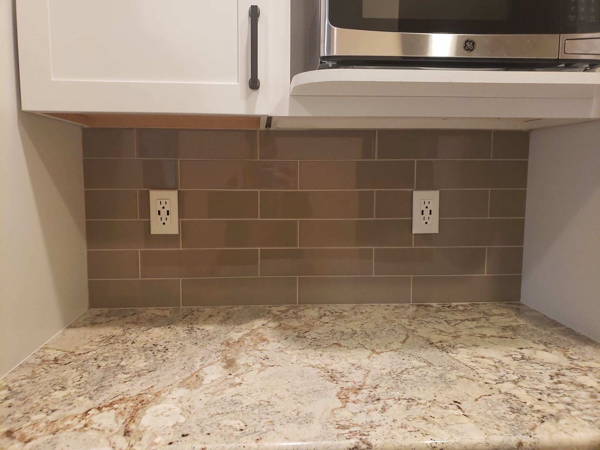 A kitchen with granite counter tops and a microwave oven.