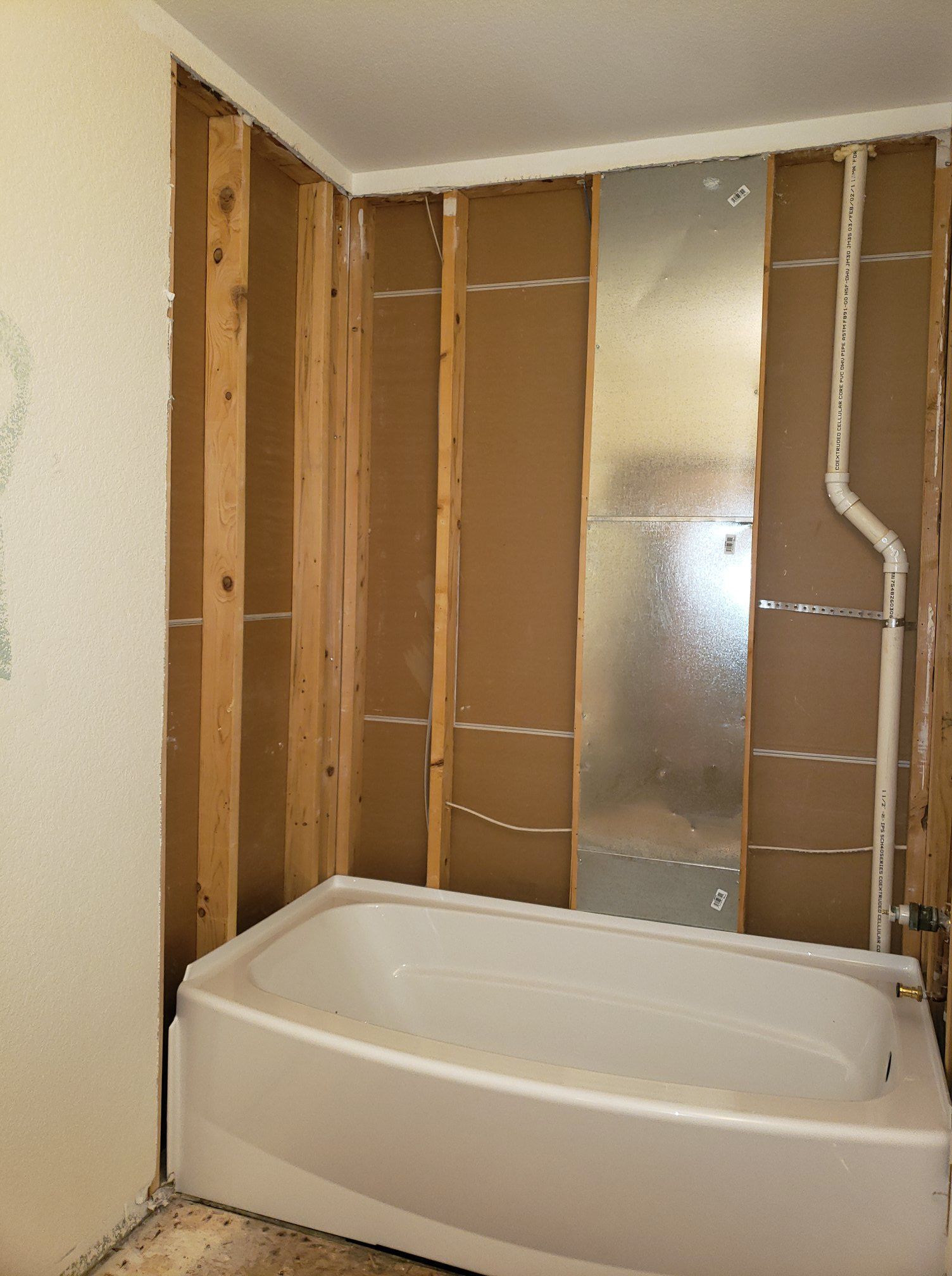 A bathtub is sitting in a bathroom under construction.