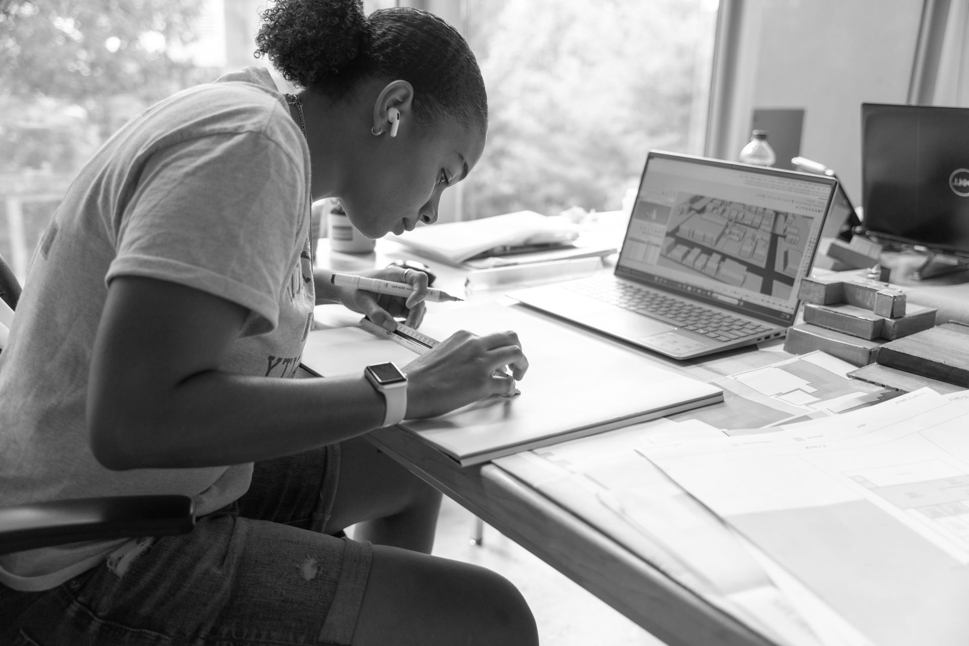 A woman concentrated sketching architecture plans for a class assignment