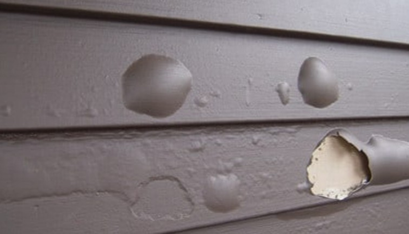 Brown painted siding with bubbles and peeling paint.