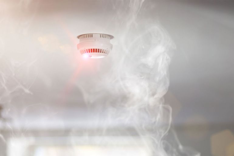 For Smoke Damage Restoration, the image shows smoke drifting up to a ceiling-mounted fire detector.