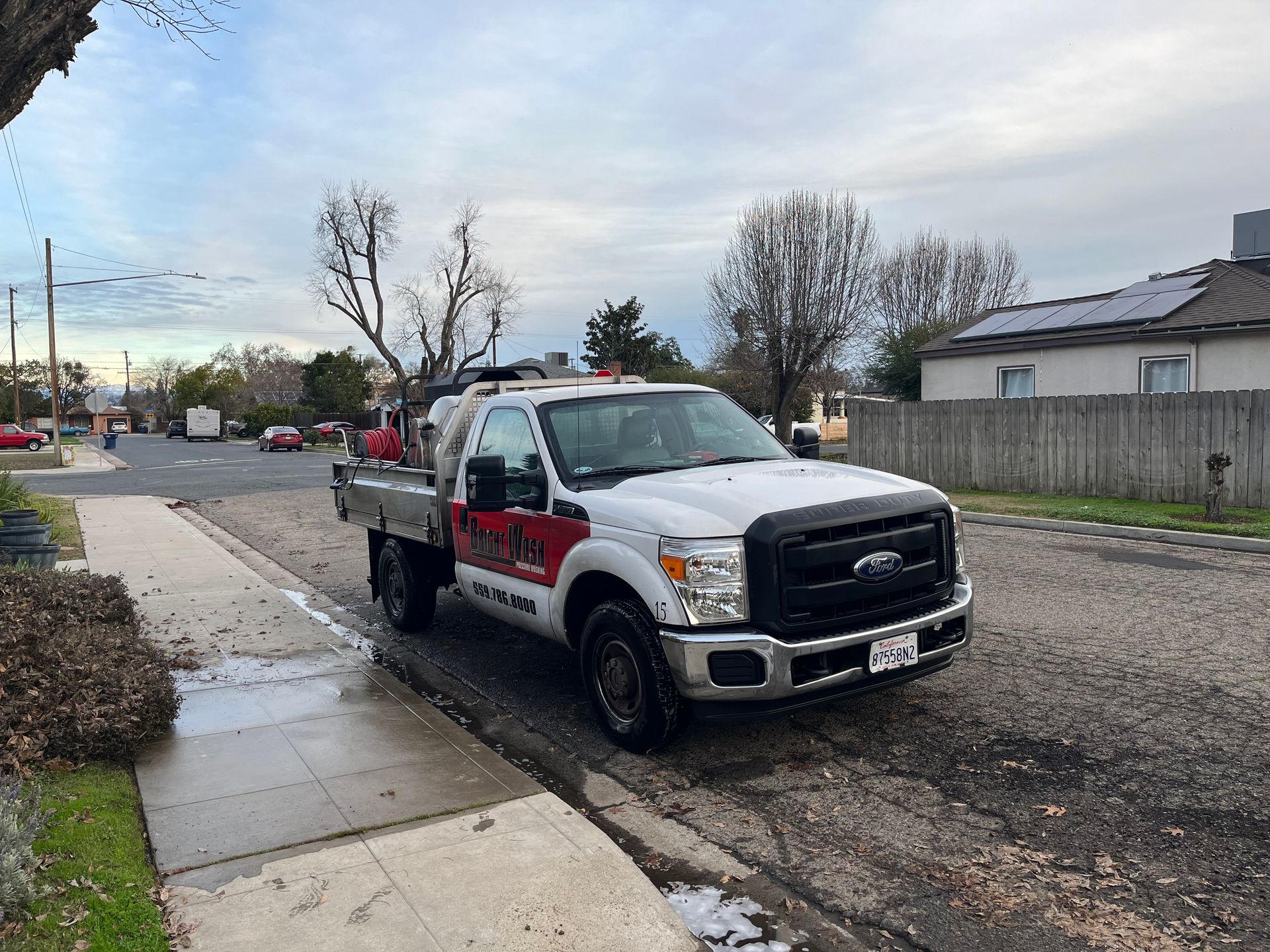 A white tow truck is parked on the side of the road.