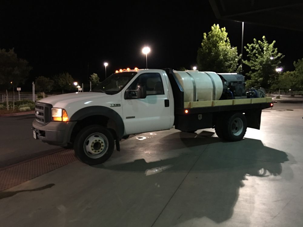 A white truck is parked in a parking lot at night