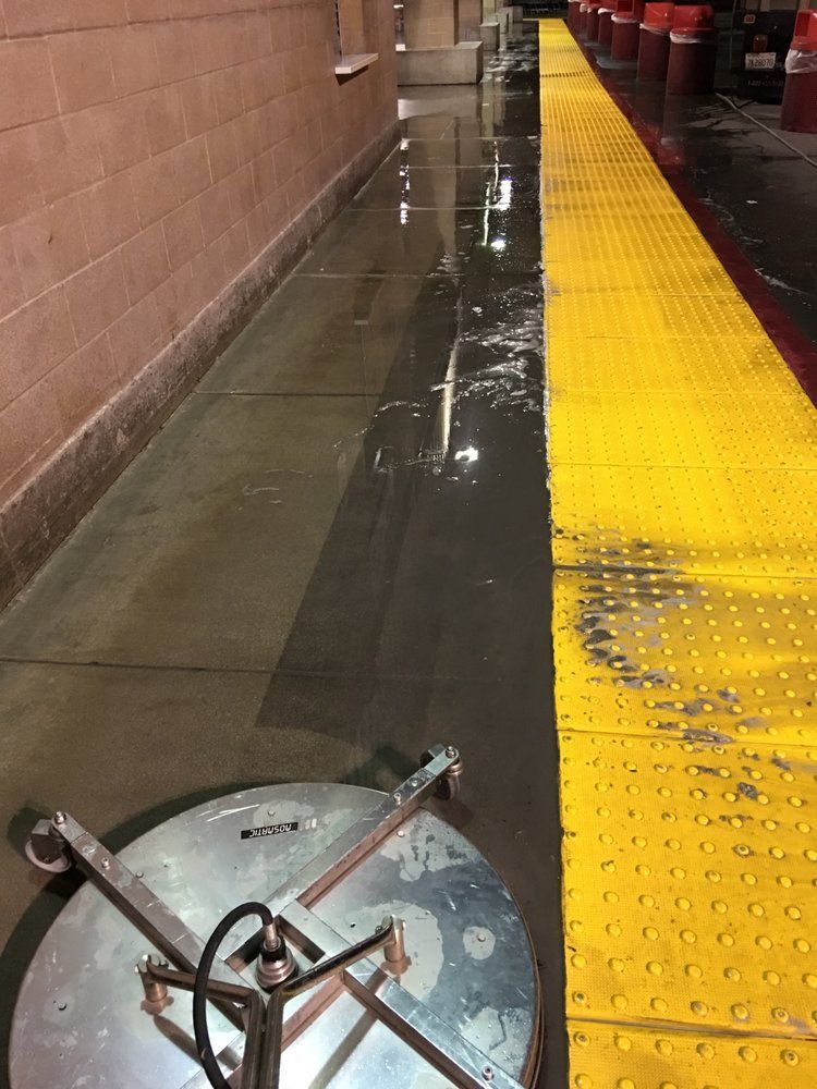 A train station with a yellow walkway and a dirty floor