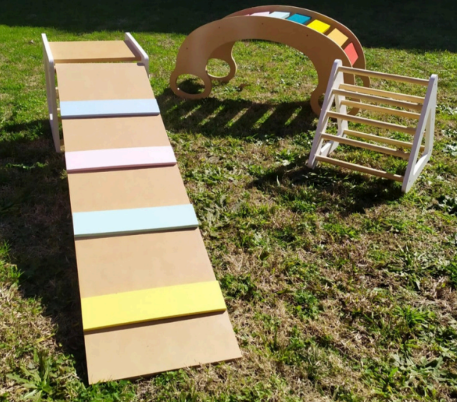 Tres juguetes de escalada de madera para niños se encuentran sobre el césped