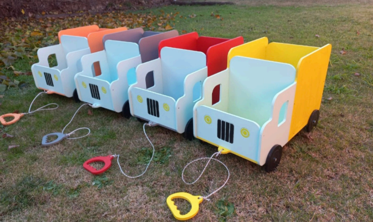 Seis camiones de juguete de colores en fila sobre el césped