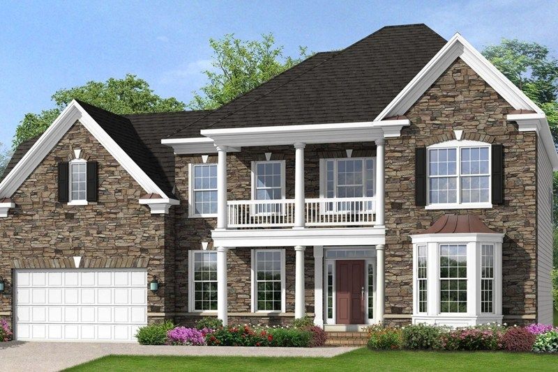 Two-story house with stone facade, white trim, balcony, and black roof. Includes a garage, and landscaping.