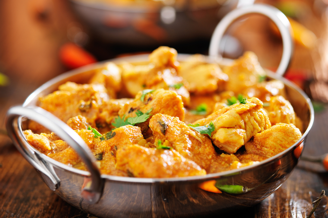 A mouthwatering bowl of curry chicken, featuring tender pieces of chicken