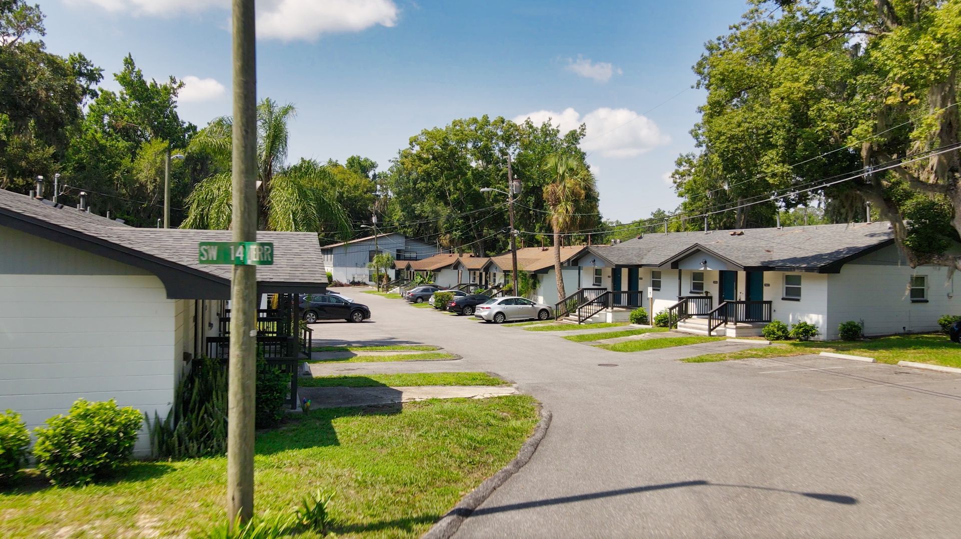 A row of apartment buildings are lined up on the side of a street.