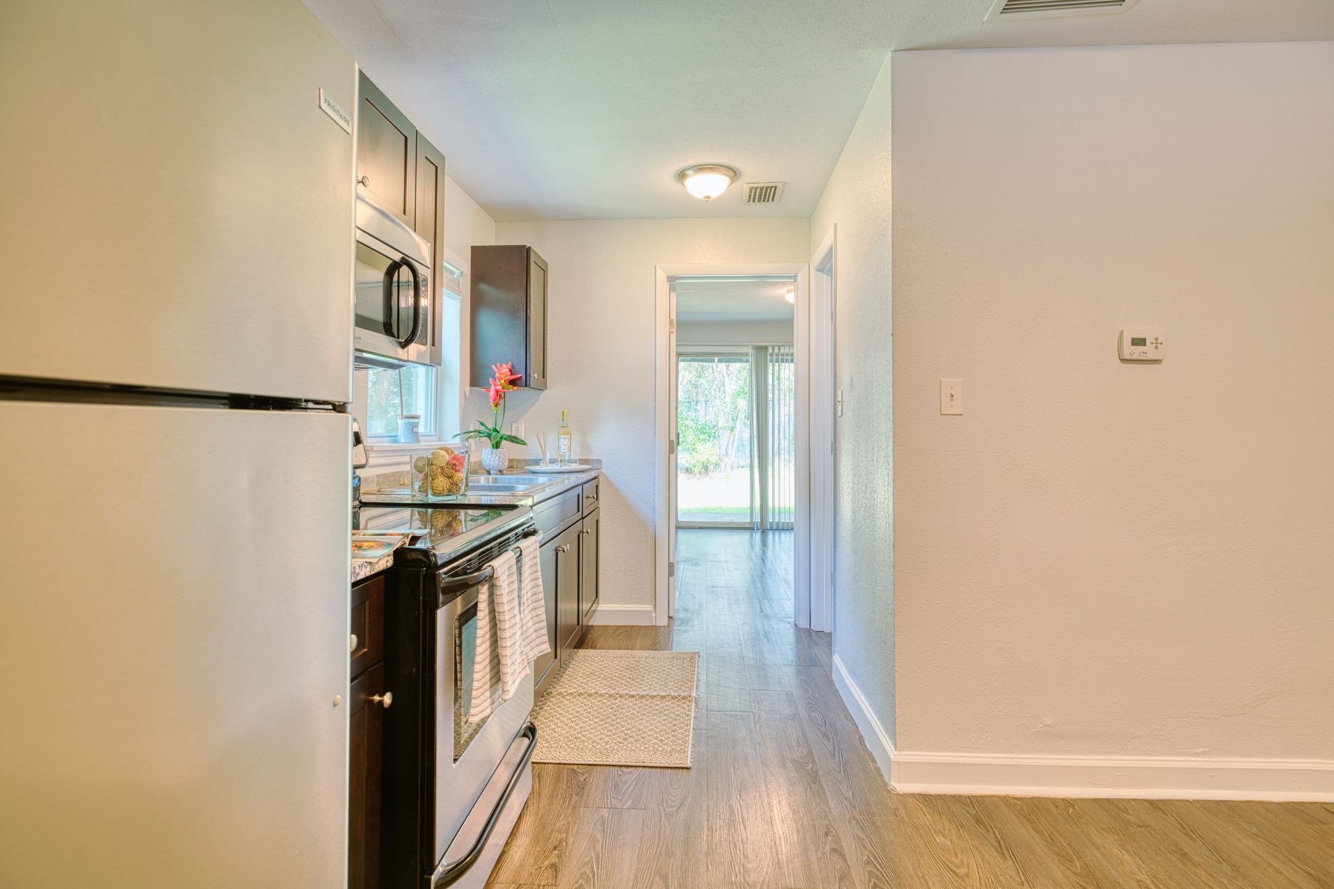 A kitchen with a refrigerator , stove , microwave and sink.