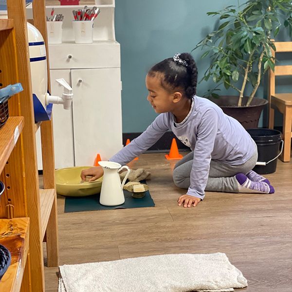 Montessori child learning to use a hammer