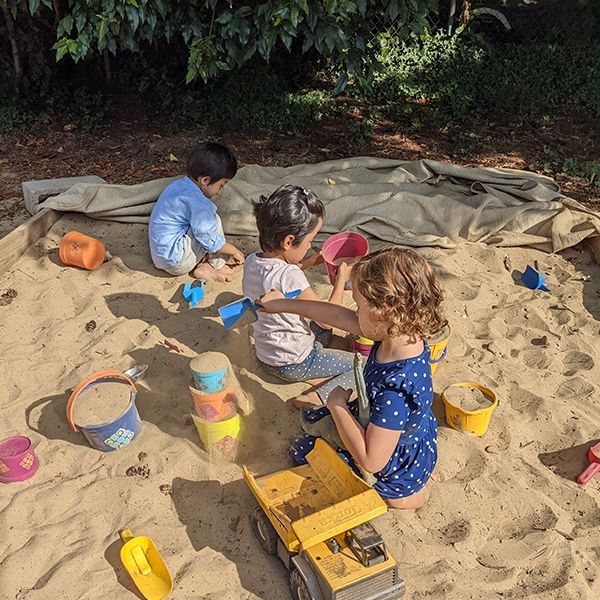 montessori toddler playing inside the sandbox