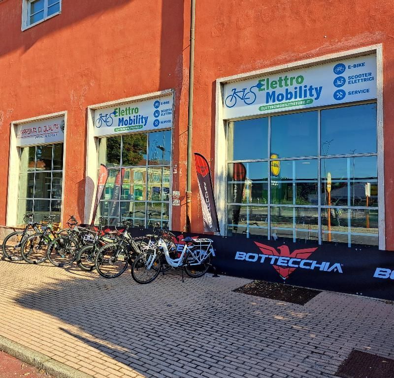 Una fila di biciclette è parcheggiata davanti a un negozio chiamato elettro mobilità
