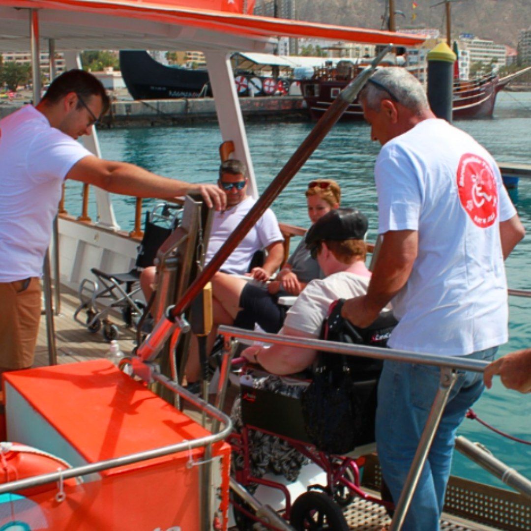 Eine Gruppe von Menschen ist auf einem Boot und einer von ihnen sitzt im Rollstuhl