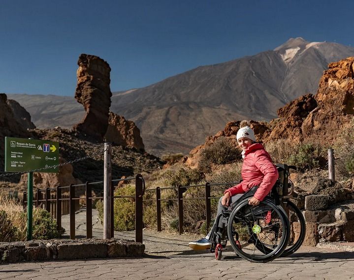 Eine Frau im Rollstuhl ist auf einer barrierefreien Wanderung.