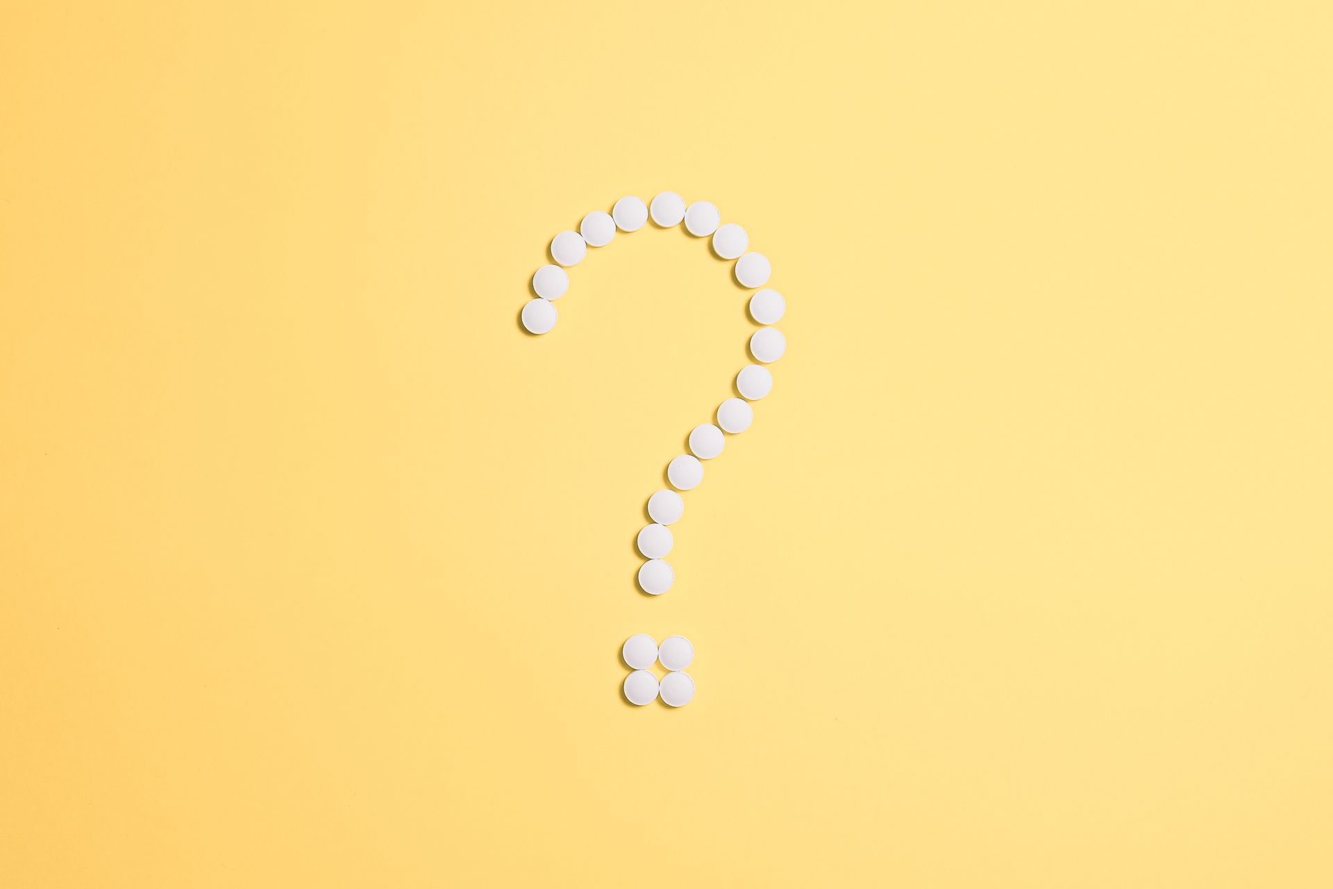 Fragezeichen aus Tabletten – Sinnbild für die Frage, wer welche Pflegeaufgaben übernehmen darf.